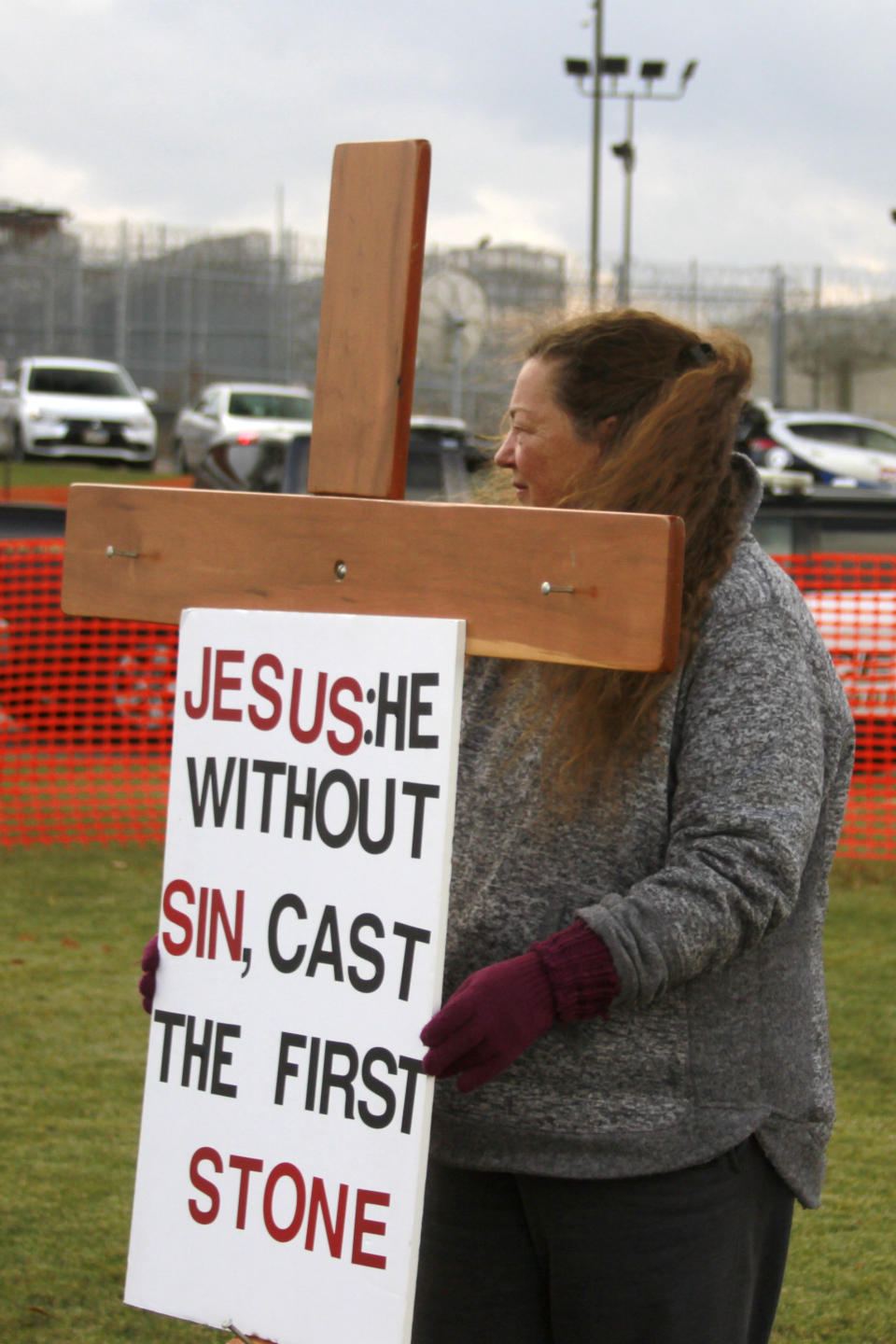 A protester holds a cross and sign during an anti-death penalty protest outside the South Dakota State Penitentiary in Sioux Falls, Monday, Nov. 3, 2019, where Charles Russell Rhines is scheduled to die Monday, by lethal injection for the death of a former co-worker. Officials are waiting to hear from the United States Supreme Court on three appeals filed by Rhines. The state attorney general's office said it will not proceed with the execution until the Supreme Court rules on the matter. (AP Photo/Stephen Groves)