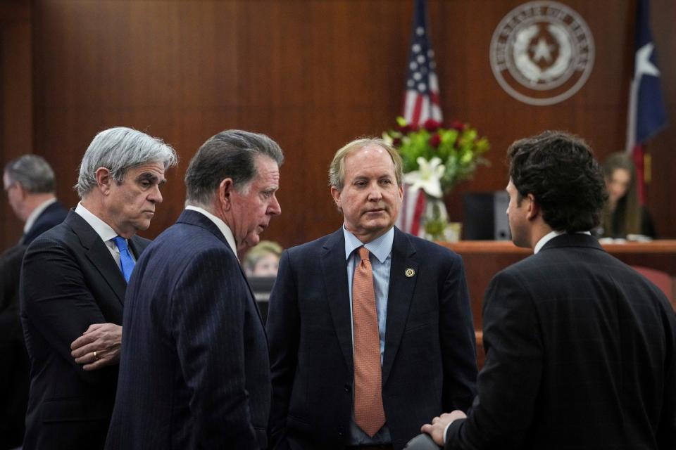 Texas Attorney General Ken Paxton, second from right, talks Friday with his defense attorneys, from left, Philip Hilder, Dan Cogdell and Anthony Osso Jr. at the Harris County criminal courthouse in Houston. A judge at Friday's pretrial hearing rejected Paxton’s attempts to dismiss felony securities fraud charges that have shadowed the Republican for nearly a decade.