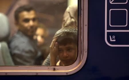A migrant child looks out through the window of a train at Keleti train station in Budapest, Hungary, September 5, 2015. REUTERS/David W Cerny