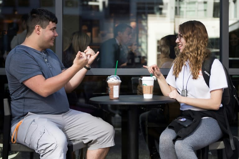 Students Nikolas Carapellatti and Rebecca Witzofsky (R) at the opening of the first Starbucks "signing store" in the United States -- in the capital Washington