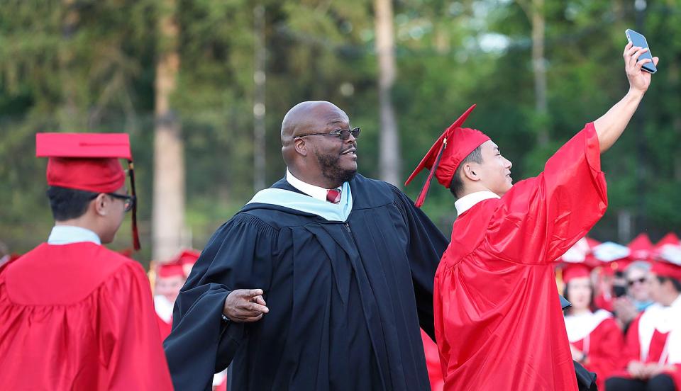 A student takes one last selfie with Principal Keith Ford onstage at North Quincy High's commencement at Veterans Memorial Stadium on Monday, June 6, 2022.