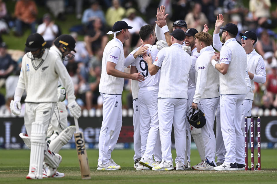 England players celebrate the wicket of New Zealand's Devon Conway, left, on the second day of the second cricket test between England and New Zealand at the Basin Reserve in Wellington, New Zealand, Saturday, Feb. 25, 2023. (Andrew Cornaga/Photosport via AP)