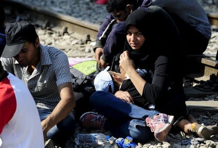 A migrant nurses her baby while waiting with others on the Greek side of the border to enter Macedonia near Gevgelija, Macedonia, en route to northern Europe July 20, 2015. REUTERS/Ognen Teofilovski