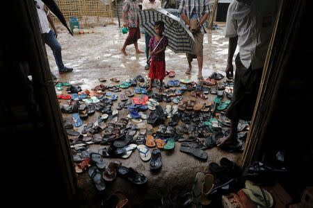 A girl holds an umbrella as Rohingya refugees arrive for a Friday prayer at a mosque in a camp for those who recently fled from Myanmar, near Cox's Bazar, Bangladesh October 6, 2017. REUTERS/Damir Sagolj