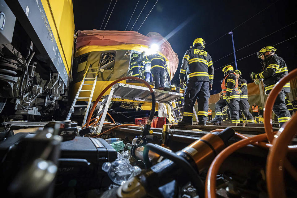 In this photo released by Fire Department of Pardubice region, rescue workers help injured passengers after two trains collided in Pardubice, Czech Republic Thursday, June 6, 2024. A passenger train collided head-on with a freight train in the Czech Republic, killing and injuring some people, officials said early Thursday. (Fire Department of Pardubice region via AP)