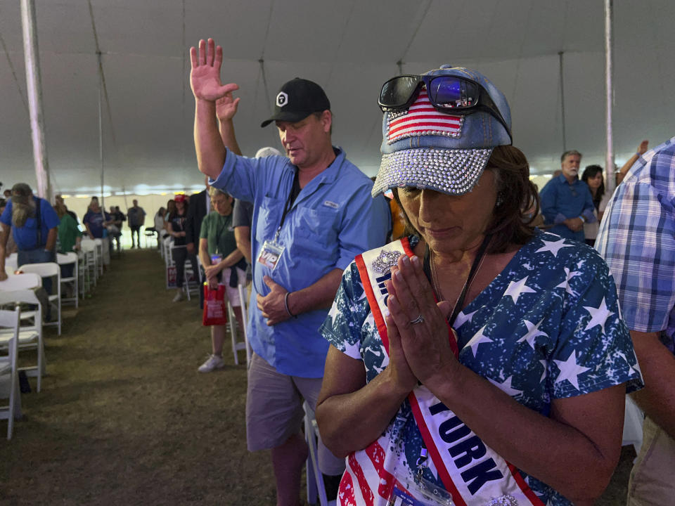 People in the audience pray during the ReAwaken America Tour at Cornerstone Church in Batavia, N.Y., Friday, Aug. 12, 2022. A poll by the University of Maryland conducted in May found that 61 percent of Republicans support declaring the U.S. to be a Christian nation. (AP Photo/Carolyn Kaster)