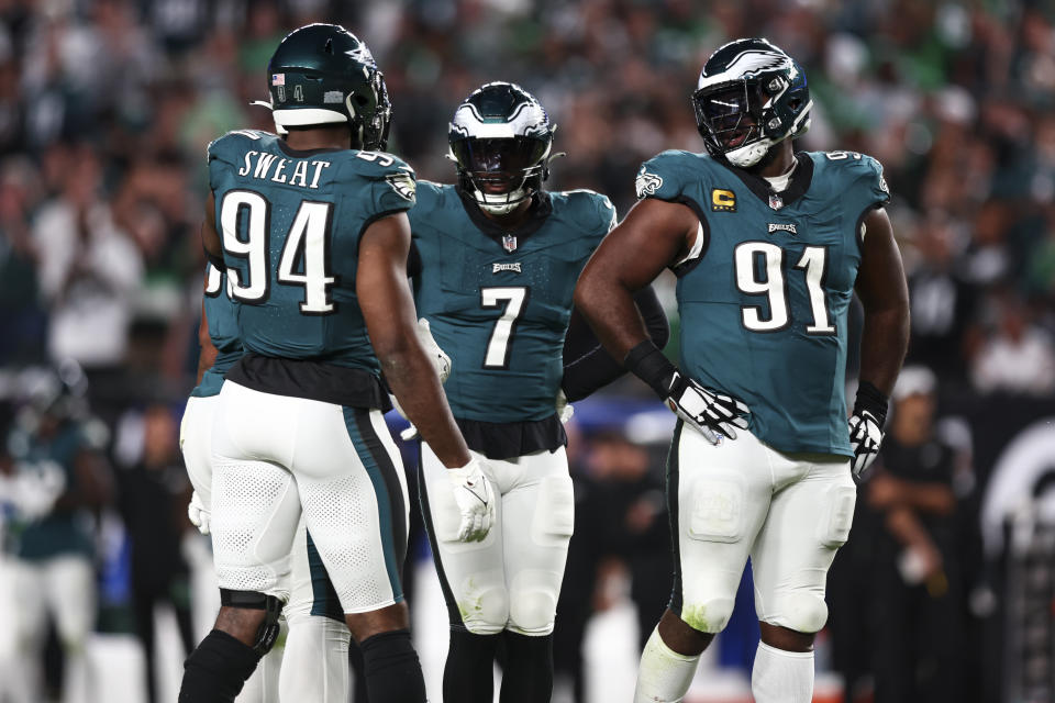 Josh Sweat #94 of the Philadelphia Eagles talks with Haason Reddick #7 and Fletcher Cox