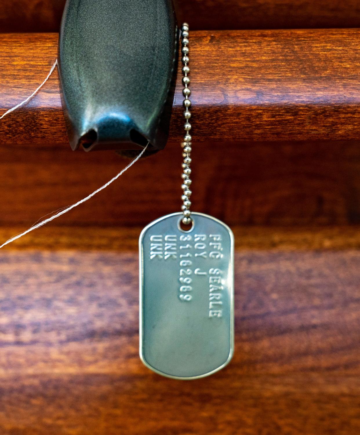 Dog tags hang from Army Pfc. Roy J. Searle's casket.