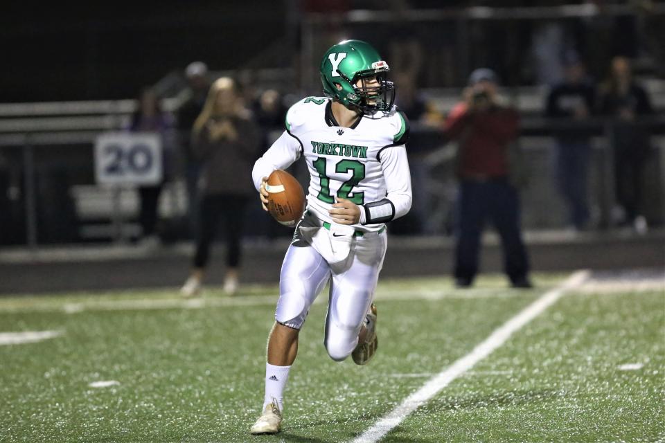 Yorktown football quarterback Mason Moulton scrambles in the team's sectional championship game at Norwell High School on Friday, Nov. 4, 2022.