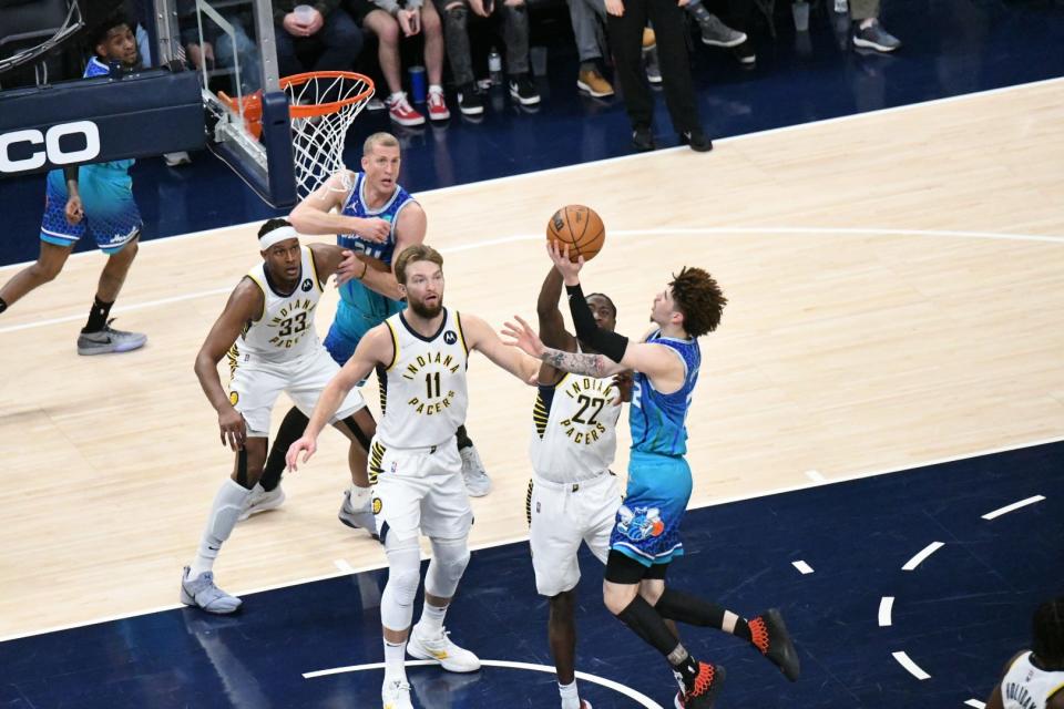 Charlotte's LaMelo Ball shoots layup over Indiana's Caris LeVert as the Pacers host the Hornets at Gainbridge Fieldhouse in Indianapolis on Dec. 29, 2021.