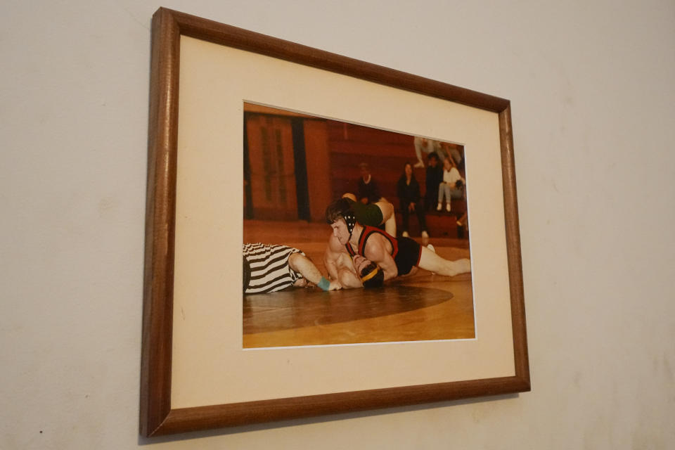 A picture frame displays Anthony Kelly, top, participating in a wrestling match in high school, Tuesday, May 2, 2023, in Baltimore. Kelly has been using help from the Baltimore City Health Department's harm reduction program RV, which is used to address the opioid crisis, which includes expanding access to medication assisted treatment by deploying a team of medical staff to neighborhoods with high rates of substance abuse and offering buprenorphine prescriptions. (AP Photo/Julio Cortez)