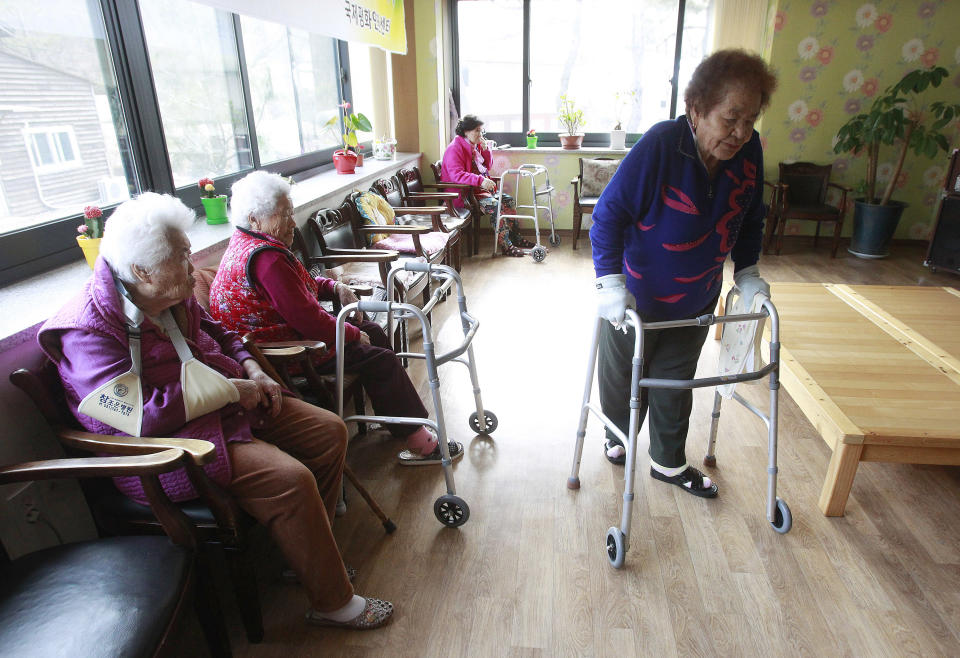 Kim Gun-ja, 89, right, former comfort woman who was forced to serve for the Japanese troops as a sexual slave during World War II, passes by other comfort woman Yi Ok-seon, 88, left, and Kim Wei-han, 86, at the House of Sharing, a nursing home and museum for 10 former sex slaves, in Toechon, South Korea. There are only 55 women left who registered with the South Korean government as former sex slaves from the war _ down from a peak of more than 230. Their average age is 88. (AP Photo/Ahn Young-joon)