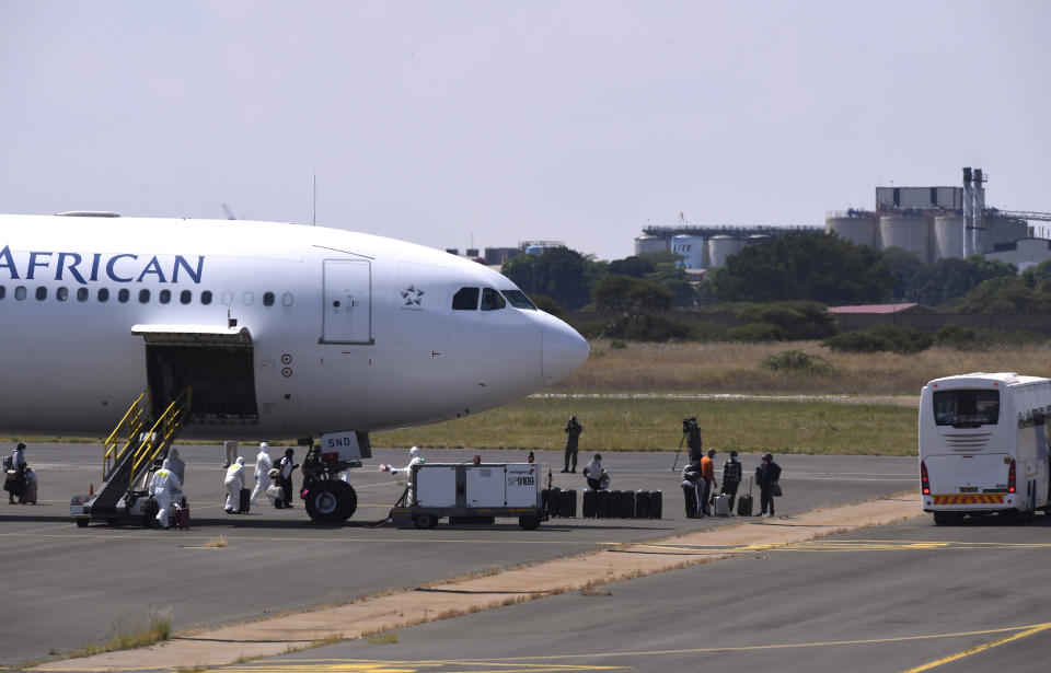 Passengers disembark from a plane on their arrival in Polokwani, South Africa, Saturday, March 14, 2020 after being repatriated from Wuhan, China where they will be kept in quarantine at a nearby resort. For most people the new coronavirus causes only mild or moderate symptoms, such as fever and cough. For some, especially older adults and people with existing health problems, it can cause more severe illness, including pneumonia. (AP Photo)