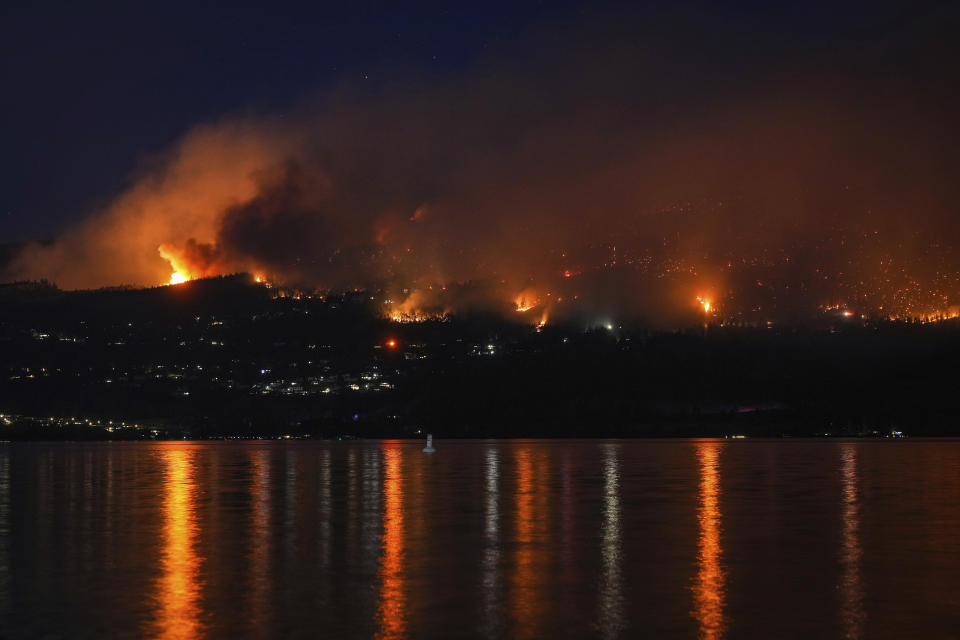 The McDougall Creek wildfire burns on the mountainside above lakefront homes in West Kelowna, Canada on Friday, Aug. 18, 2023. (Darryl Dyck/The Canadian Press via AP)