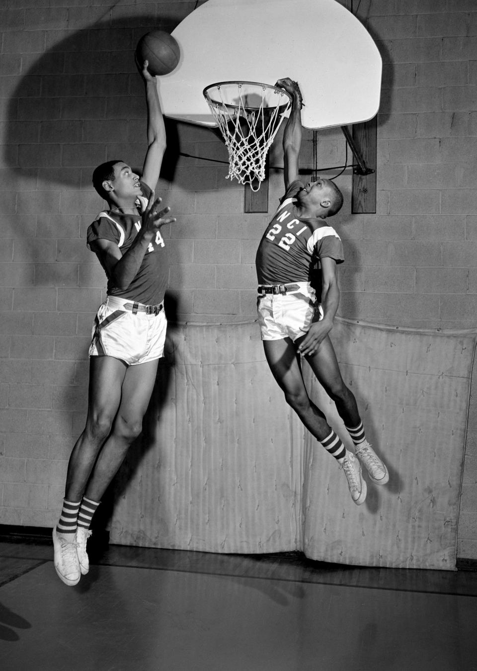 Everyone can jump at Nashville Christian Institute, but it's a longer trip for some. Reginal Harding (44), 7-1 center, takes a little hop to put the ball high over the rim while 5-9 William Muncy soars to put his hand over the basket at the school Jan. 10, 1962.