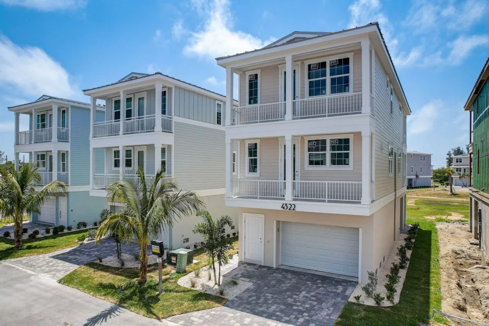 A completed Hunters Point home with a palm tree in the front yard 