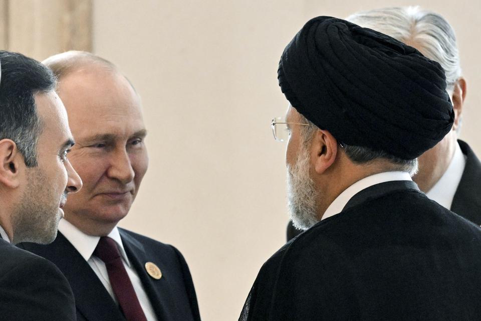 FILE - Russian President Vladimir Putin, left, speaks to Iran's President Ebrahim Raisi, back to a camera, on the sideline of the summit of Caspian Sea littoral states in Ashgabat, Turkmenistan, on June 29, 2022. Putin's visit to Iran starting Tuesday, July 19, is intended to deepen ties with regional heavyweights as part of Moscow's challenge to the United States and Europe amid its grinding campaign in Ukraine. (Grigory Sysoyev, Sputnik, Kremlin Pool Photo via AP, File)