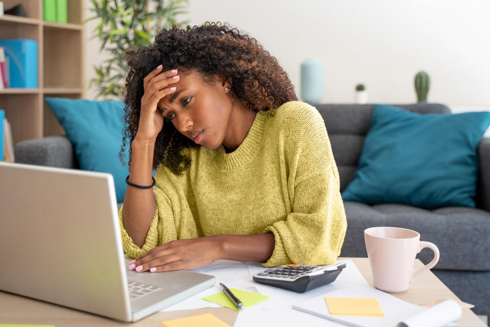 A woman stressing in front of her laptop