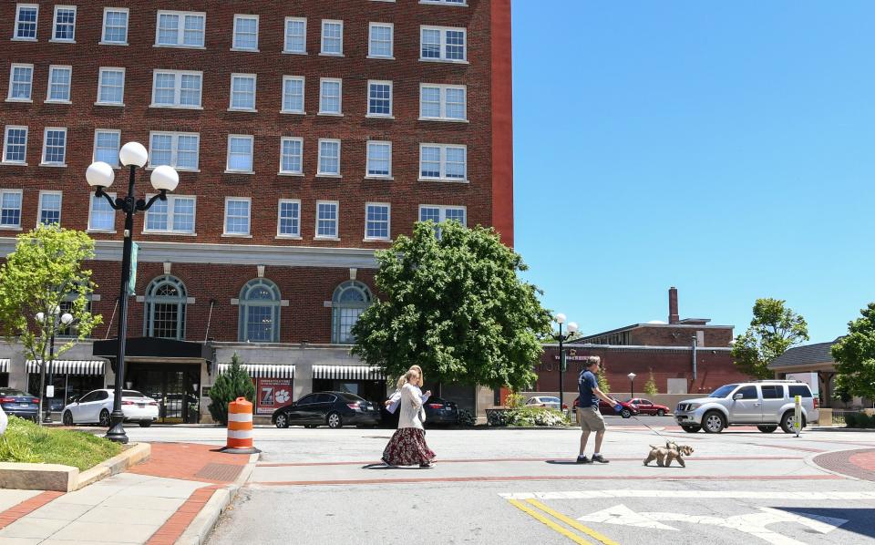 Rick and Ann Kummrow walk their dog with daughter Alexa near The Calhoun Lofts Apartments, across the street from the building they bought at 401 North Main Street in downtown Anderson. The couple pitched their plan to create The Historic Postmark Anderson, a mix of housing upstairs, retail on the main floor, and possibly a restaurant downstairs. The structure built in 1909 was previously a funeral home, and before that a United States Post Office.