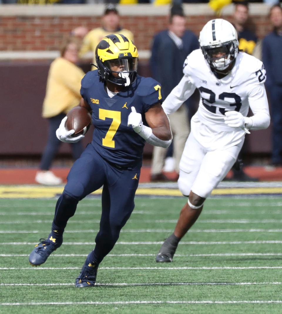 Michigan running back Donovan Edwards (7) runs by Penn State linebacker Curtis Jacobs during the second half Oct. 15, 2022 at Michigan Stadium in Ann Arbor.