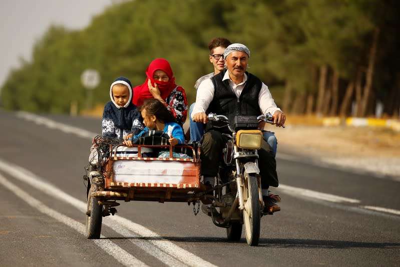 People drive on a motorcycle in the border town of Ceylanpinar