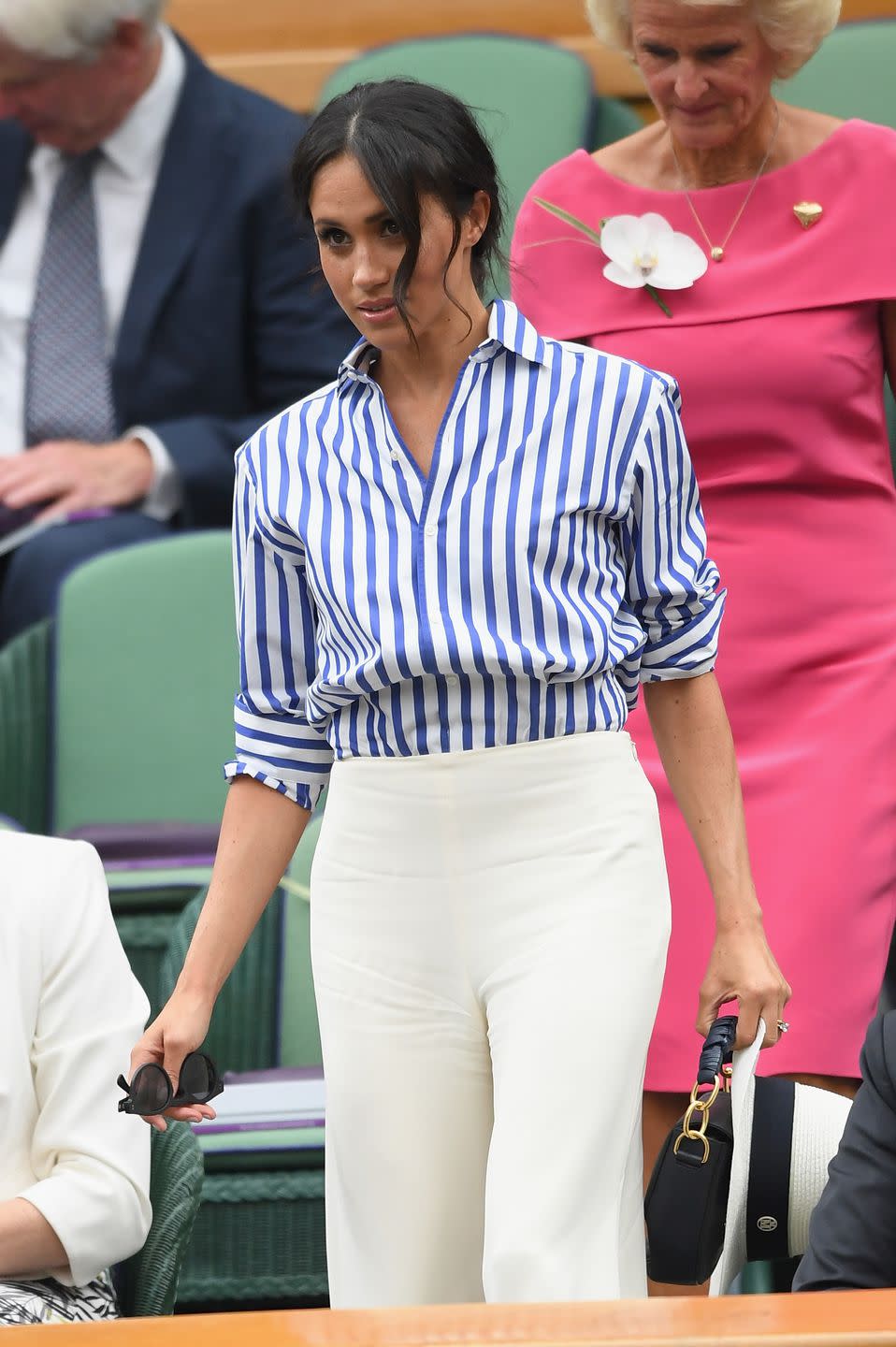 <p>Meghan Markle arrives wearing a <a rel="nofollow noopener" href="https://www.harpersbazaar.com/celebrity/latest/a22147362/meghan-markle-wimbledon-2018-ralph-lauren-prince-harry/" target="_blank" data-ylk="slk:Ralph Lauren shirt;elm:context_link;itc:0;sec:content-canvas" class="link ">Ralph Lauren shirt</a> and silk pants.</p>