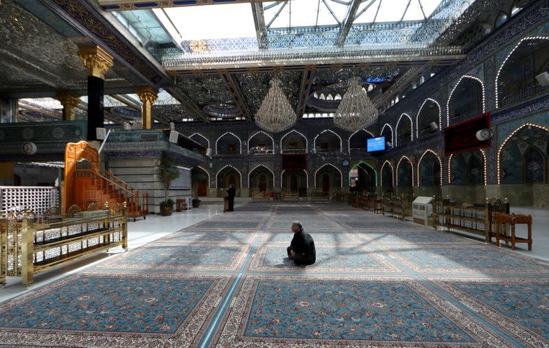 FILE PHOTO: A man sits inside empty Imam Abbas shrine, as Friday prayers were suspended following the spread of the coronavirus disease (COVID-19), in the holy city of Kerbala