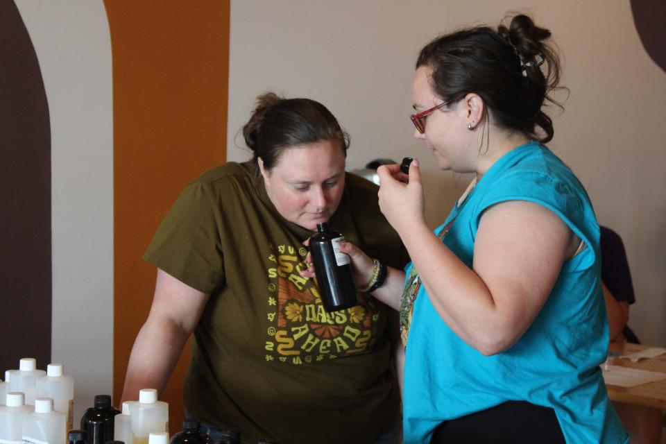 (L-R) Sisters Kendra Whittle and Asheley Graves smell candle scents at the Maggie's Farm and Aromatics "Brew and Burn" event at 50 West on July 26, 2023.