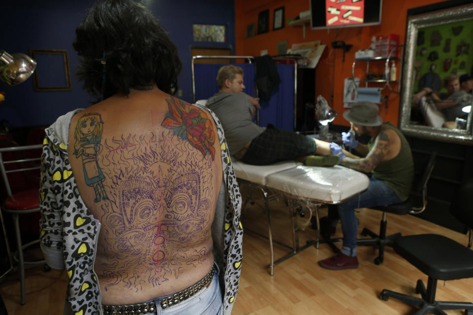 En esta foto del 5 de septiembre de 2018, Gabriela Irigoyen Aguilar muestra el esbozo del tatuaje de una máscara tradicional japonesa que planea tatuarse en el salón de tatuajes Corona en la Ciudad de México. (AP Foto / Marco Ugarte)