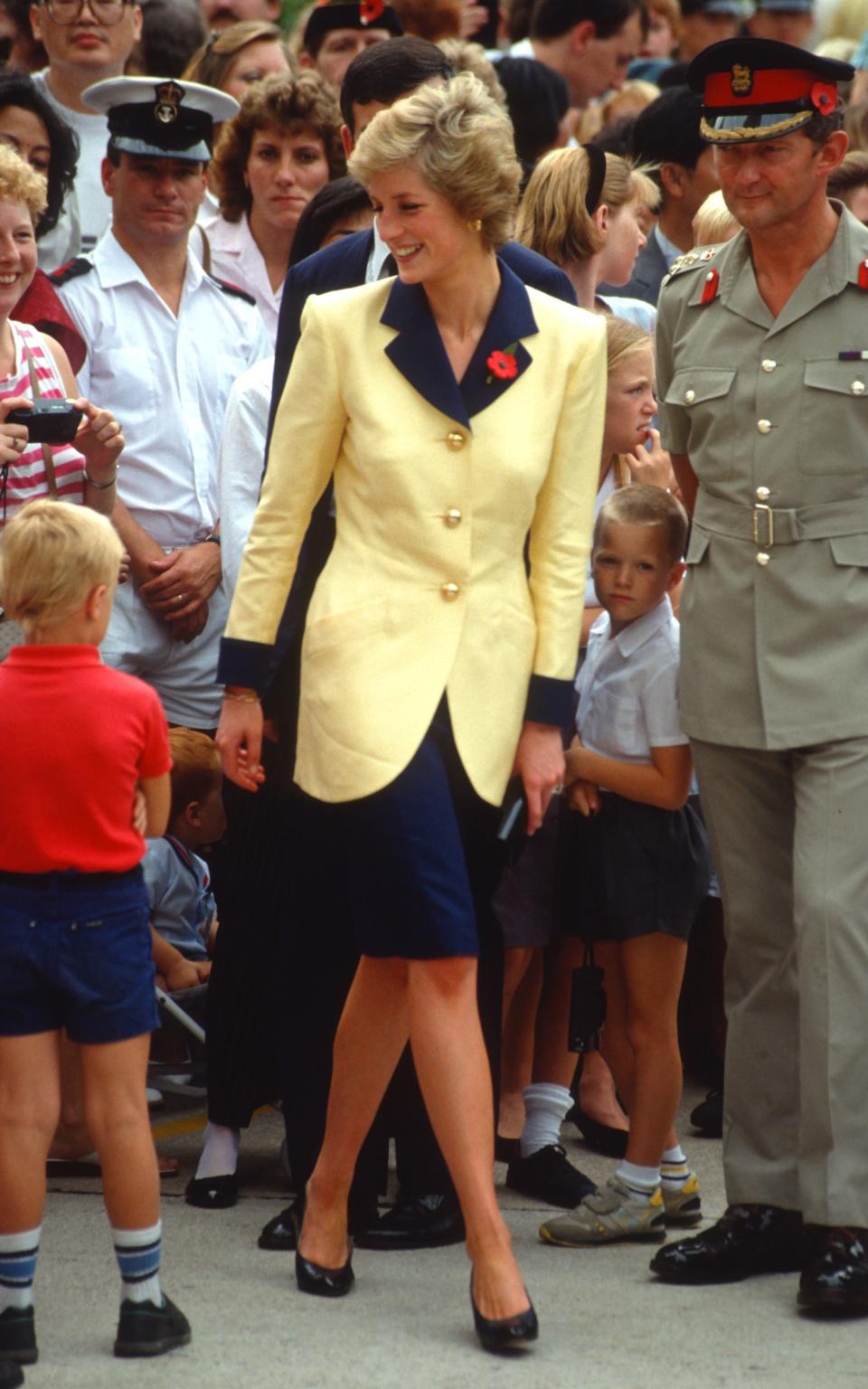 The Princess wearing the yellow and navy skirt suit during a visit to Hong Kong in 1989