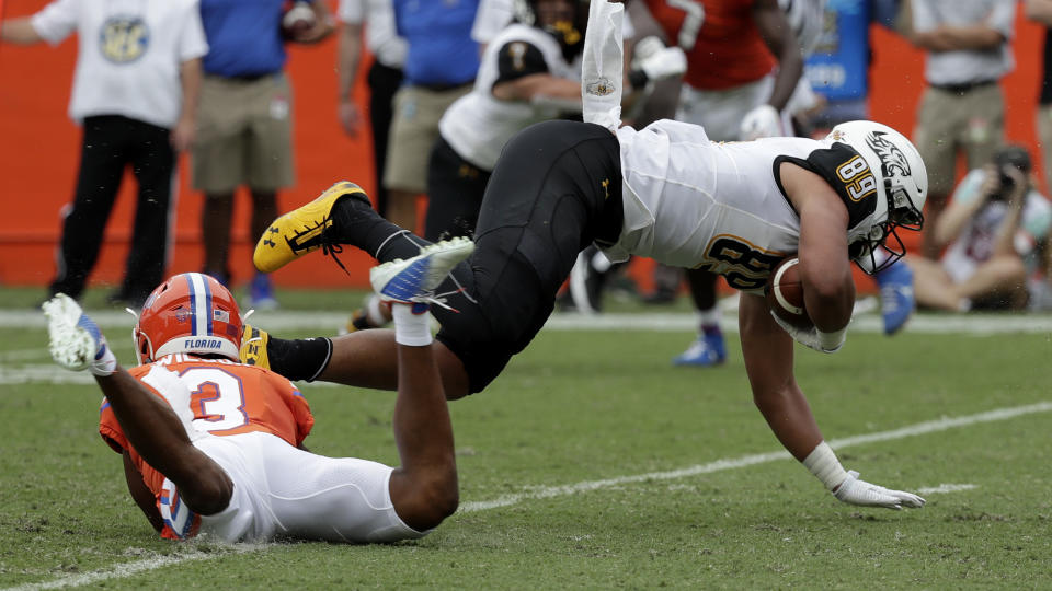 Towson tight end Jason Epps, right, is upended by Florida defensive back Marco Wilson after a pass reception during the first half of an NCAA college football game, Saturday, Sept. 28, 2019, in Gainesville, Fla. (AP Photo/John Raoux)