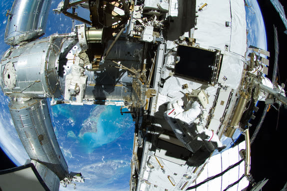 With the Andros Island and other parts of the Bahamas in the backdrop, NASA astronaut Sunita Williams and Japanese astronaut Akihiko Hoshide (out of frame) work on the exterior of the International Space Station during an Aug. 30, 2012 spacewal