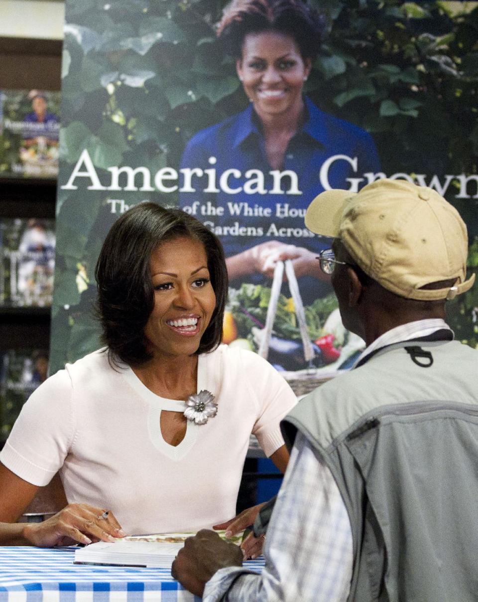 First lady Michelle Obama signs copies of her book "American Grown: The Story of the White House Kitchen Garden and Garden Across America," in Washington, Tuesday, June 12, 2012. (AP Photo/Jacquelyn Martin)