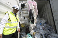 Officers from the Ministry of Environment examine a container full of non-recyclable plastic which was detained by authorities at the west port in Klang, Malaysia, Tuesday, May 28, 2019. Malaysia environment minister Yeo Bee Yin says Malaysia has become a dumping ground for the world's plastic waste, and the country has begun sending non-recyclable plastic scrap to the developed countries of origin. (AP Photo/Vincent Thian)