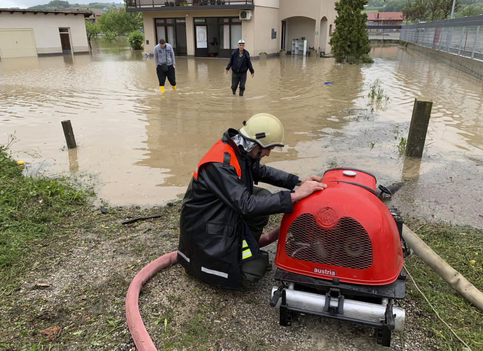 A firefighter pumps water out of a flooded home in Doboj, Bosnia, Tuesday, May 14, 2019. Overflowing rivers in Bosnia and Croatia have flooded dozens of homes and roads, putting the Balkans on high alert after 2014 floods killed dozens of people died and submerged large areas of the region. (AP Photo/Eldar Emric)