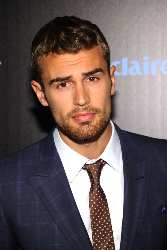 Theo in a tailored suit and polka-dot tie posing for a photo