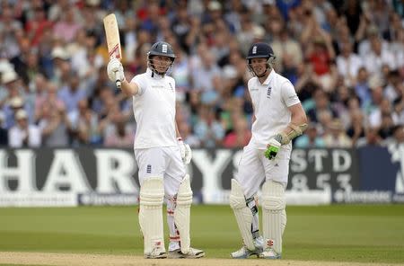 England's Gary Ballance (L) lifts his bat after reaching his half century as he stands with teammate Sam Robson during the first cricket test match against India at Trent Bridge cricket ground in Nottingham July 11, 2014. REUTERS/Philip Brown