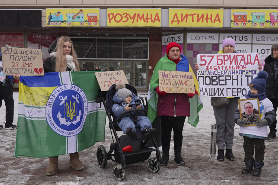 Kateryna Dmytryk, left, takes part in a prisoners of war families protest with her 2-year-old son, Timur, in Kyiv, Ukraine, Jan.14, 2024. Her husband was in Russian captivity at the time. (AP Photo/Vasilisa Stepanenko)