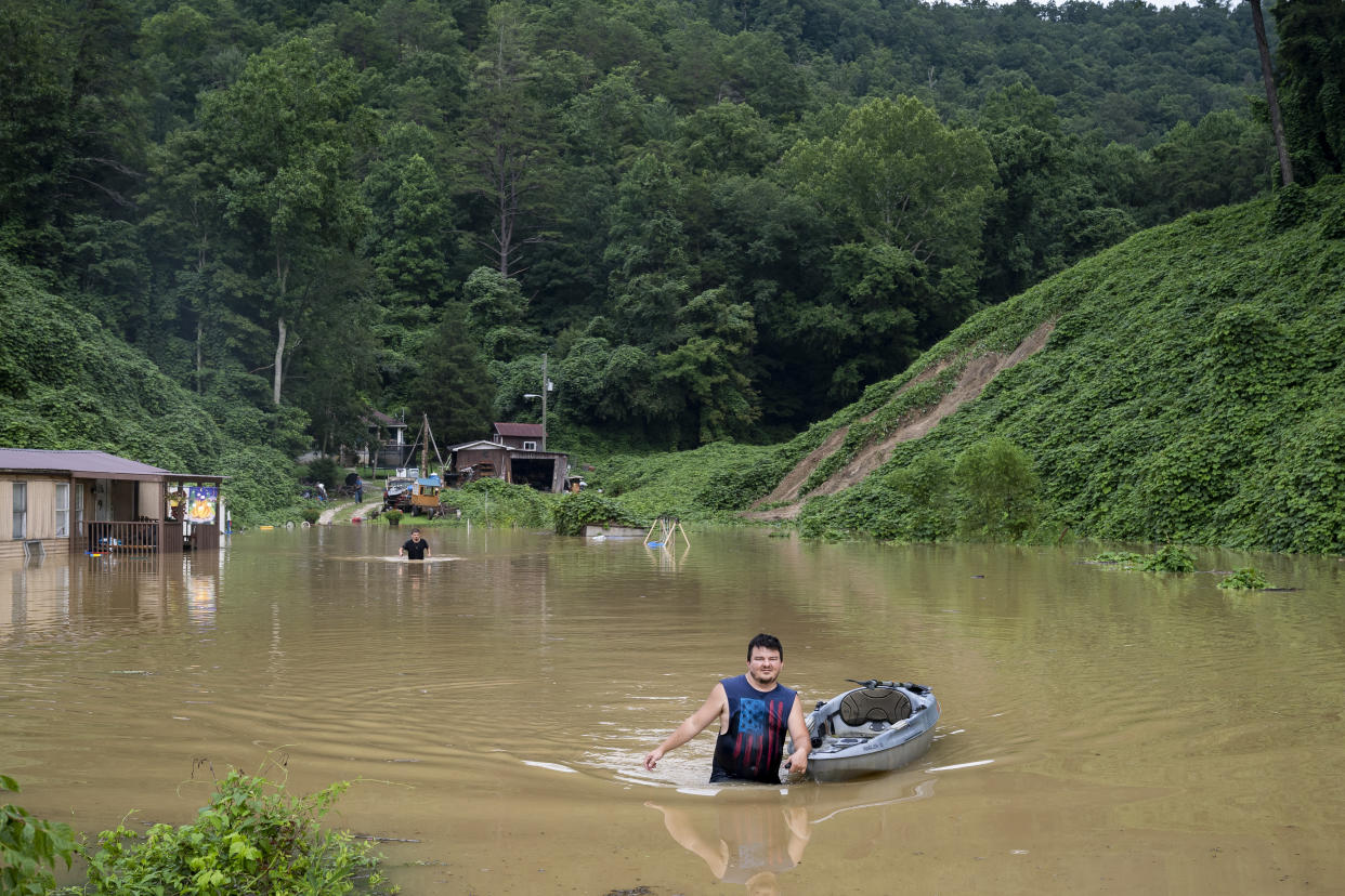 Lewis Ritchie pulls a kayak through the water after delivering groceries to his father-in-law near Jackson, Ky., on Thursday. 