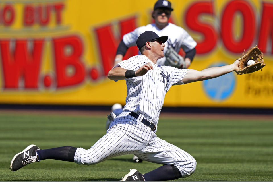 New York Yankees second baseman DJ LeMahieu, left, reaches for a fly ball to short right field as teammate Clint Frazier, right, runs in from the outfield during the sixth inning of a baseball game, Sunday, May 23, 2021, at Yankee Stadium in New York. (AP Photo/Kathy Willens)