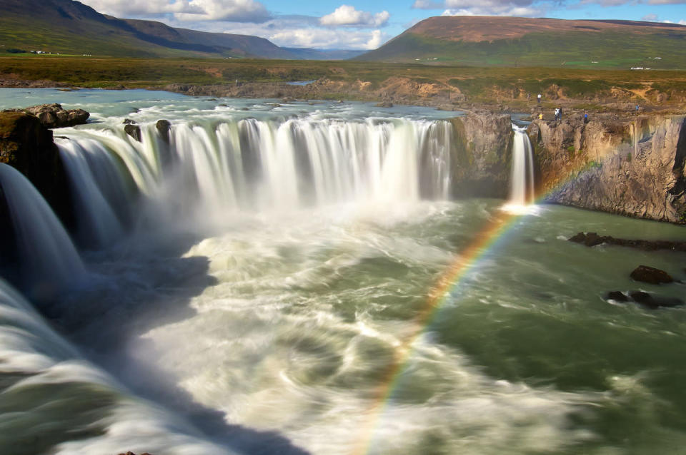 A landscape view of a rainbow appearing near a waterfall. (Michael Fersch/Caters News Agency)