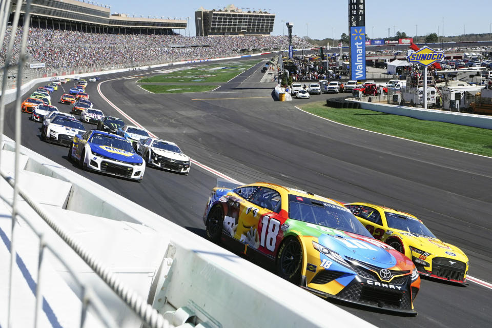 NASCAR Cup Series driver Kyle Busch (18) battels Joey Logano (22) as they go into Turn One during the NASCAR Cup Series auto race at Atlanta Motor Speedway in Hampton, Ga., Sunday, March 20, 2022. (AP Photo/John Bazemore)