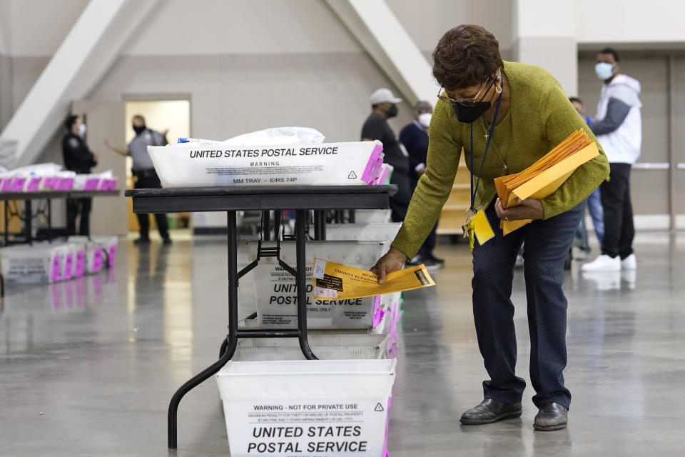 A election official works around ballots during a Milwaukee hand recount of presidential votes at the Wisconsin Center, Friday, Nov. 20, 2020, in Milwaukee. The recount of the presidential election in Wisconsin’s two most heavily Democratic counties began Friday with President Donald Trump’s campaign seeking to discard tens of thousands of absentee ballots that it alleged should not have been counted. (AP Photo/Nam Y. Huh)