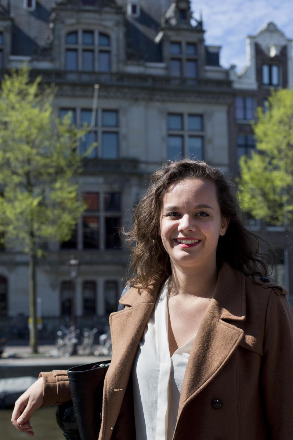 Fotografía del miércoles 16 de abril de 2014 de Charlotte van den Berg posando fuera del Instituto para Estudios de Guerra, Holocausto y Genocidios (al fondo), en Amsterdam, Holanda. (Foto AP/Peter Dejong)