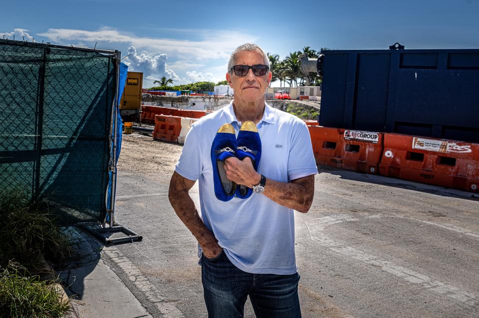 Former Champlain South resident Steve Rosenthal stands at 88th St. and Collins Ave. in Surfside, Florida, with the gold tip shoes he saved when he was rescued on the night the building collapsed.