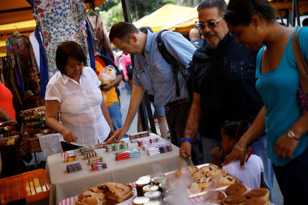 A customer looks at Mantuano chocolate bars on a street market in Caracas, Venezuela October 28, 2017. REUTERS/Carlos Garcia Rawlins