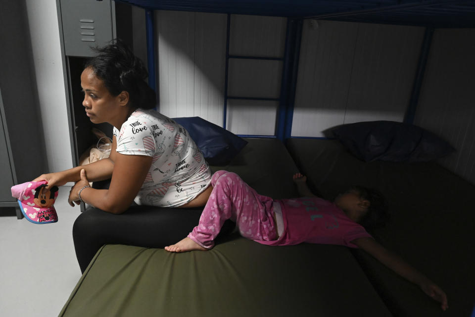A woman and a child, migrants from Venezuela, prepare to sleep at a Migrant Temporal Attention Center in Paso Canoas, Costa Rica, Monday, Oct. 16, 2023. Panama and Costa Rica launched a plan to quickly bus thousands of migrants through Panama to the Costa Rican border, as the countries continue to grapple with the increasing number of migrants. (AP Photo/Carlos Gonzalez)