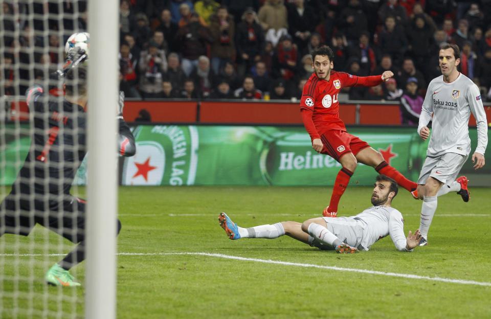 Bayer Leverkusen's Hakan Calhanoglu (C) scores a goal past Atletico Madrid's goalkeeper Miguel Angel Moya (L) during their Champions League round of 16, first leg soccer match in Leverkusen February 25, 2015. REUTERS/Ina Fassbender (GERMANY - Tags: SPORT SOCCER)