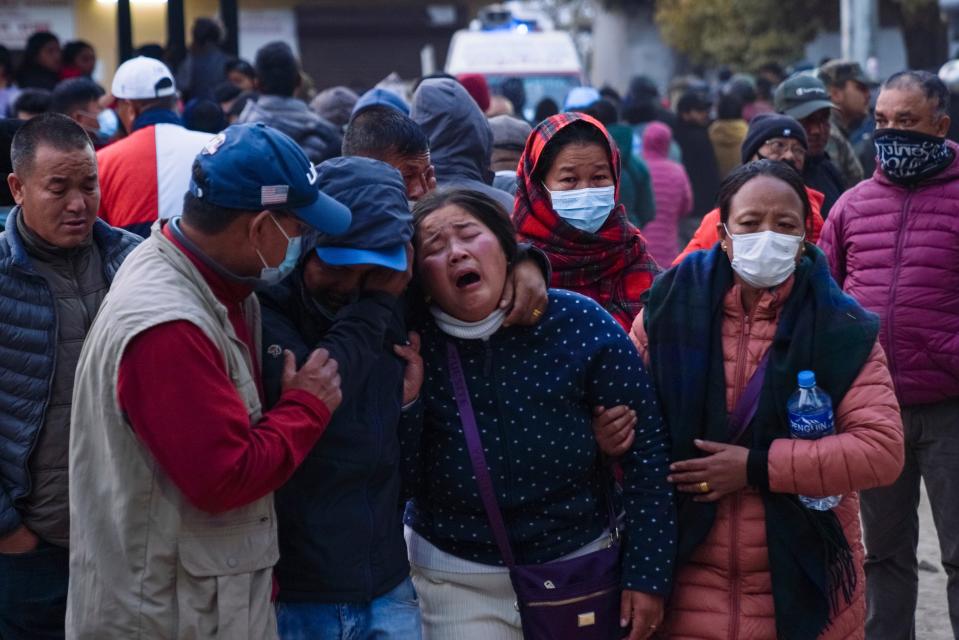 A woman cries as the body of a relative, victim of a plane crash, is brought to a hospital in Pokhara, Nepal, Sunday, Jan. 15, 2023.