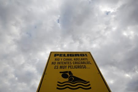 A warning sign reading "Danger. River and canal ahead. Do not try to cross them, it's very dangerous" is seen at the border with the U.S., as seen from Ciudad Juarez